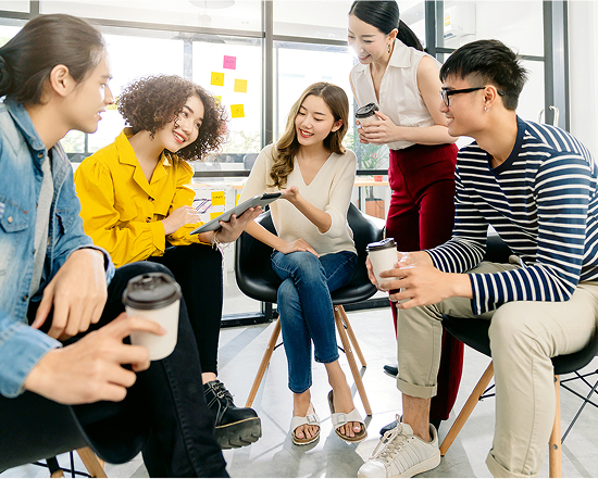 Group of employees relaxing and discussing over coffee, showing a pleasant work environment