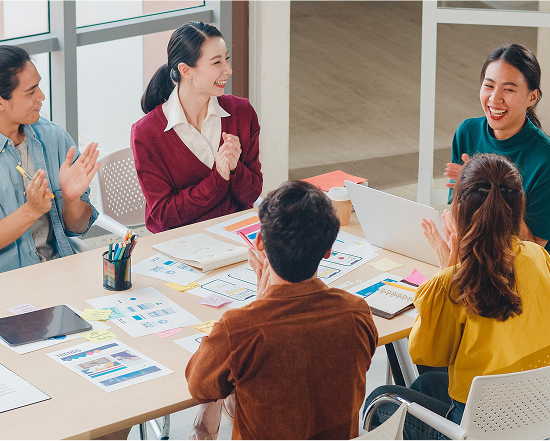 Employees applauding each other after a lively discussion in the conference room, showing positive teamwork