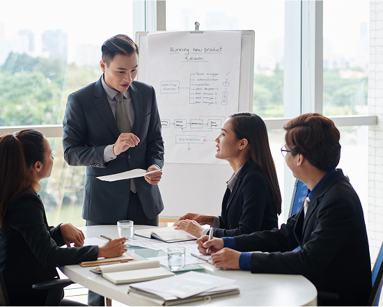 Employees listening intently to a presentation in front of a whiteboard, indicating an opportunity for learning and skill development